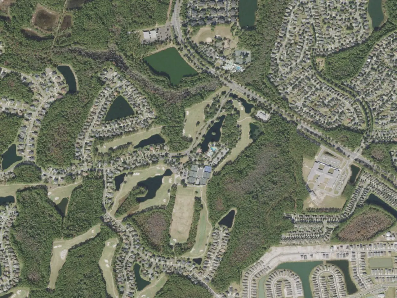 Aerial view of Eagle Landing homes, golf course, clubhouse, and wooded preserves