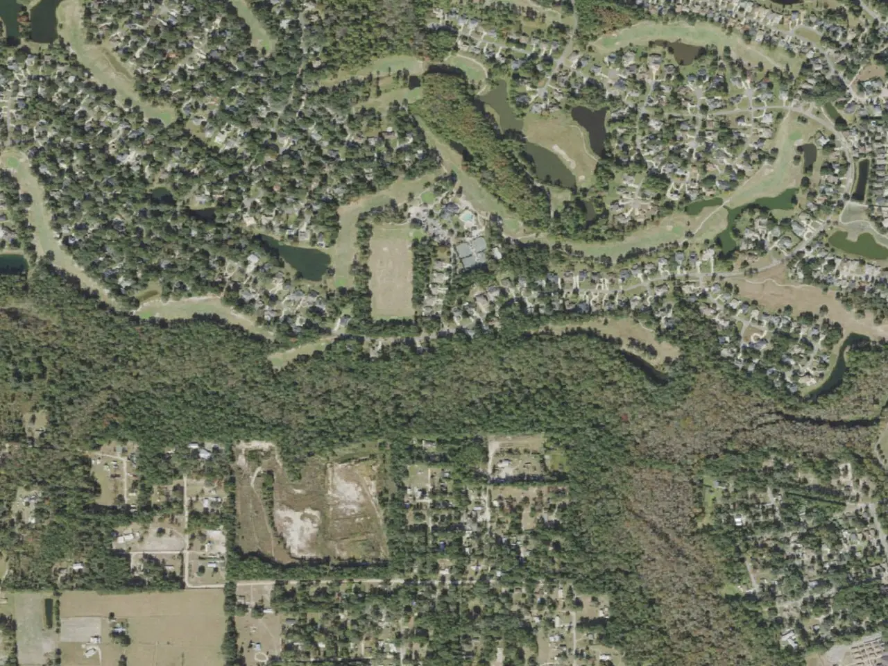 Aerial view of Magnolia Point homes, golf fairways, lakes, and wooded areas